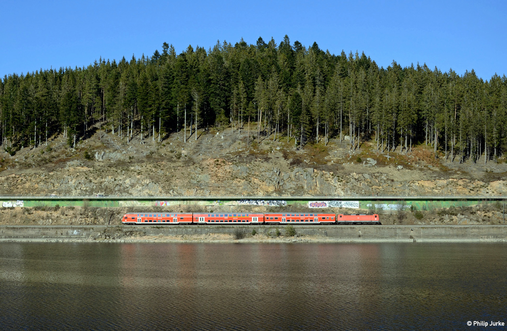 143 312-7 schiebt die RB 17276 (Seebrugg - Freiburg(Breisgau)Hbf) am 26.03.2016 an den auf der anderen Uferseite stehenden Fotografen vorbei von Seebrugg gen Schluchsee.
