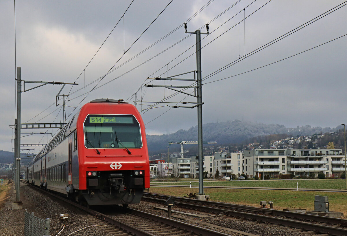 An der Strecke Zug - Zürich via Affoltern am Albis: Ein Zug der S14 der Zürcher S-Bahn kurz vor Bonstetten-Wettswil, im Hintergrund der Uetliberg. 6.Februar 2023 