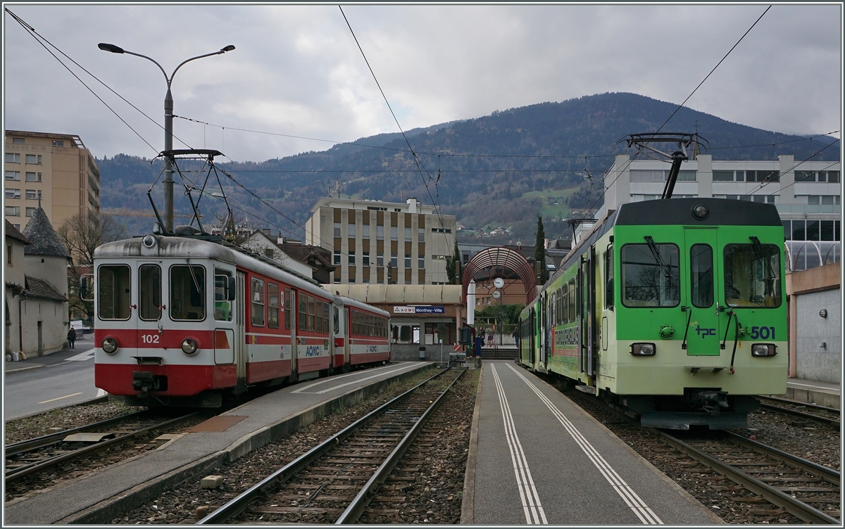 AOMC Züge nach Aigle und Champéry warten in Monthey Ville auf ihre Abfahrt: LInkd der Be 4/4 102 (ex BLT 12, 1966) und rechts der BDeh 4/4 501. 

7. April 2016
