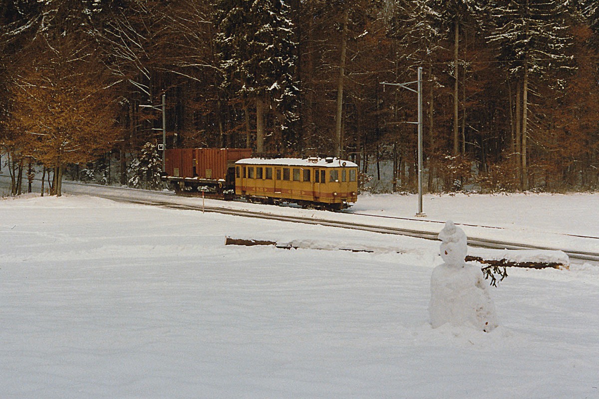ASm/OJB: Kehrichtzug Langenthal-Niederbipp mit De 4/4 122 ex LMB CFe 4/4 Nr 6 (1917) bei Bannwil  mit Schneemann  im Dezember 1985. Damals wurde der Kehricht noch von der Verladestation Langenthal mit Normalbahng�terwagen auf Schmalspur-Rollschemel zum SBB-Bahnhof Niederbipp transportiert, wo die Kehrichtwagen von einem SBB-G�terzug �bernommen wurden, der sie nach Solothurn-HB brachte. Heute werden die Kehrichtwagen nur noch auf einem kurzen Schmalspur-Streckenabschnitt auf Rollb�cken von der KEBAG-Verladestation zur ASm-Rollbockanlage Langenthal transportiert. Im September 1992 wurde der De 4/4 122 abgebrochen. Foto: Walter Ruetsch