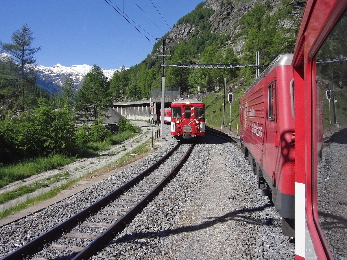 Auf der einspurigen Strecke von Visp nach Zermatt l�sst die HGe 4/4 „Mount Fuji“ der Matterhorn Gotthard Bahn an der letzten Kreuzungsstelle vor Zermatt den gerade dort gestarteten RegionalExpress vorbeifahren.