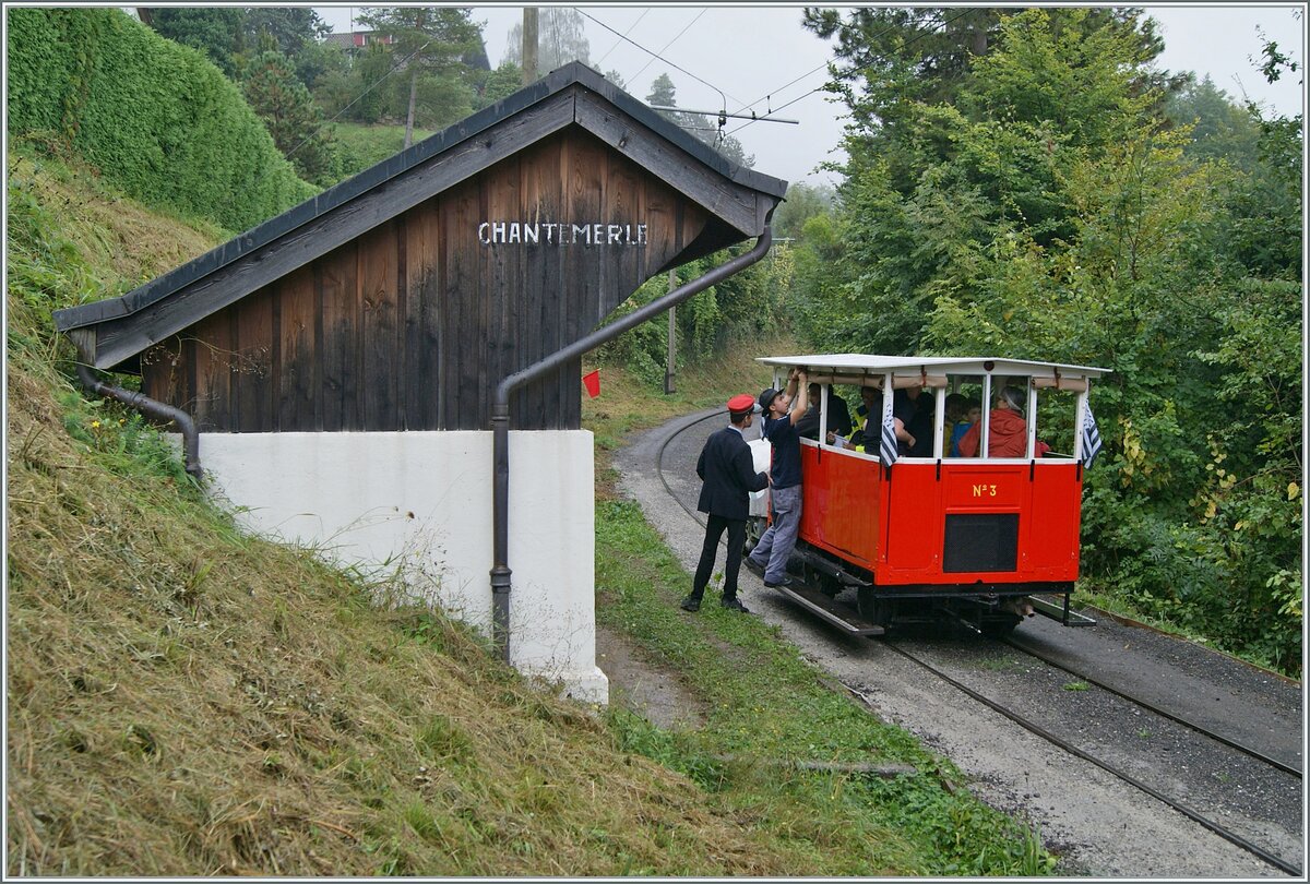 Autour de la voie ferrée / Rund um die eiserne Bahn (Herbstevent 2024) - Nachdem erstaunlich viele Reisende in der kleine Dm 2/2 N° 3  Le Biniou  Platz gefunden haben, ist der Zug praktisch für die Rückfahrt bereit. Es müssen nur noch - nach dem der Regen aufgehört hat - die Storen aufgerollt werden; ein Vorgang welcher der Chef de la Gare interessiert beaufsichtigt. Noch ein kleines, wichtiges Detail: Wenn man genau hinsieht, bemerkt man in der Bildmitte eine rote Flagge, welche als Haltesignal für andere Züge die Fahrt des Dm 2/2 absichert.

8. Sept. 2024
