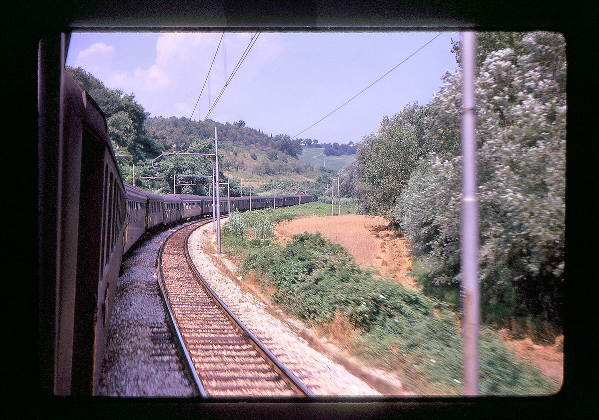 Bei diesem Bild greift man sich wirklich an den Kopf: Ein derartiges verr�cktes Konglomerat von Wagen - alles SBB-Wagen! - in Italien bei Pesaro an der Adria. Da finden sich alte schwere Wagen, Leichtstahlwagen, Schlieren-Wagen, UIC-X Wagen, alles in einem Zug, bei dem nur die Lok eine italienische ist (vermutlich Typ E636). Aufgenommen aus einem Couchettes-Wagen Typ  Schlieren . 27.Juni 1970  