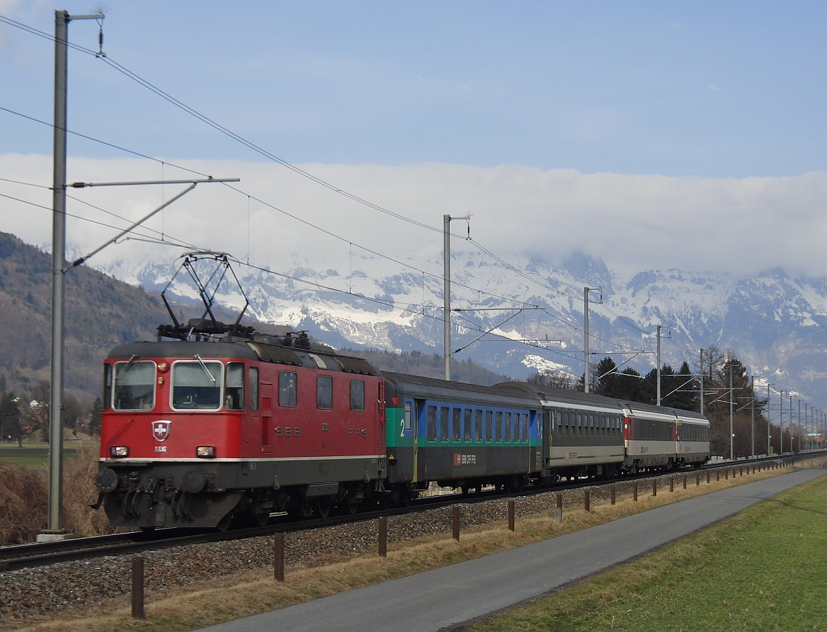 Bei Plattlis f�hrt Re 4/ II 11136 mit dem aus unterschiedlichen Wagen zusammengestellten RHEINTAL-EXPRESS RE 3811 von St. Gallen nach Chur am 06.03.2012 am Fotografen vorbei.