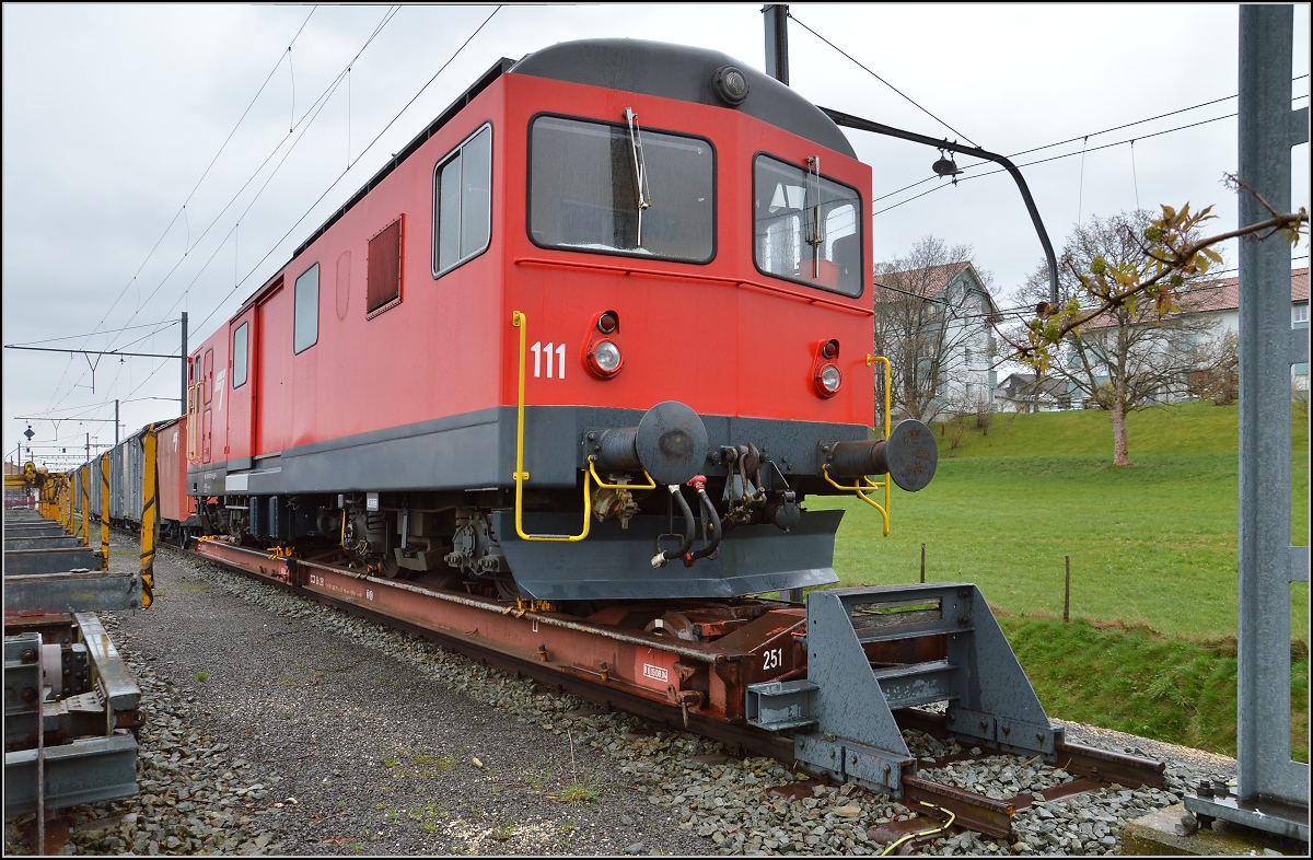 Chemins de fer de Jura (CJ). Ungewöhnlicher Rollschemelverkehr mit aufgebocktem Triebwagen De 4/4 in Saignelégier, früher auch Sankt Leodegar. April 2016.