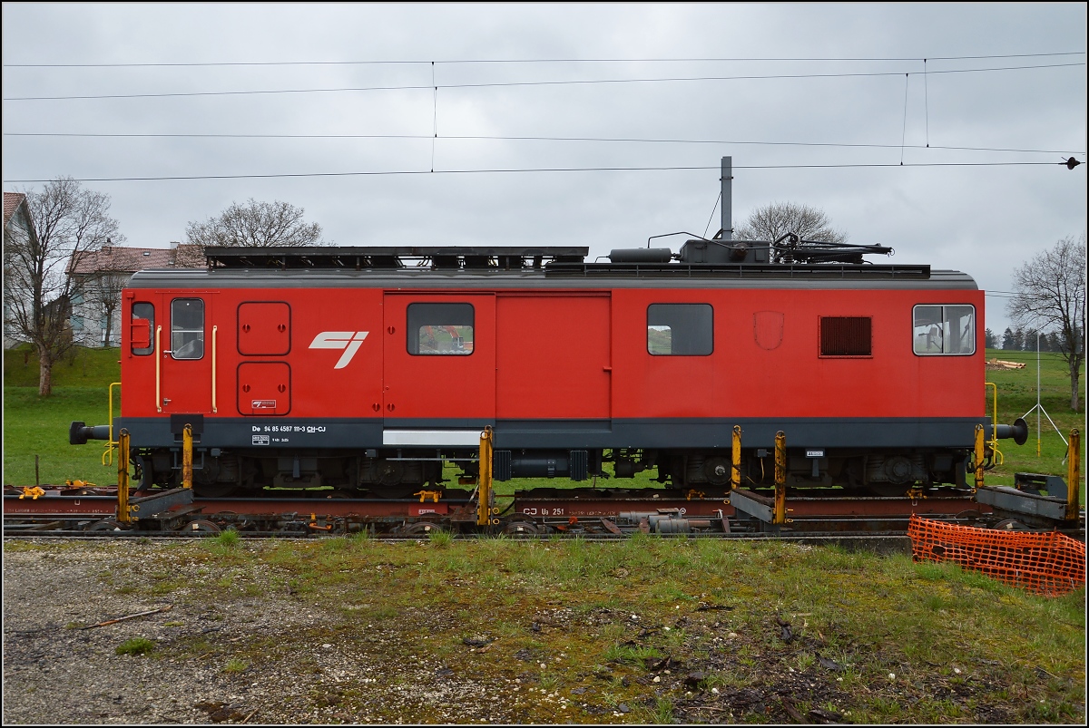 Chemins de fer de Jura (CJ). Ungewähnlicher Rollschemelverkehr mit aufgebocktem Triebwagen De 4/4 in Saignelégier. April 2016.

Dieser Gepäcktriebwagen hat eine ungewöhnliche Geschichte über mittlerweile 106 Jahre. Mangels Mitteln für eine Neubeschaffung wurden immer wieder Teile erneuert, so dass nach zahlreichen Umbauten heute wohl ein Triebwagen neueren Datums zu sehen ist, der letzte große Umbau war 1980. 