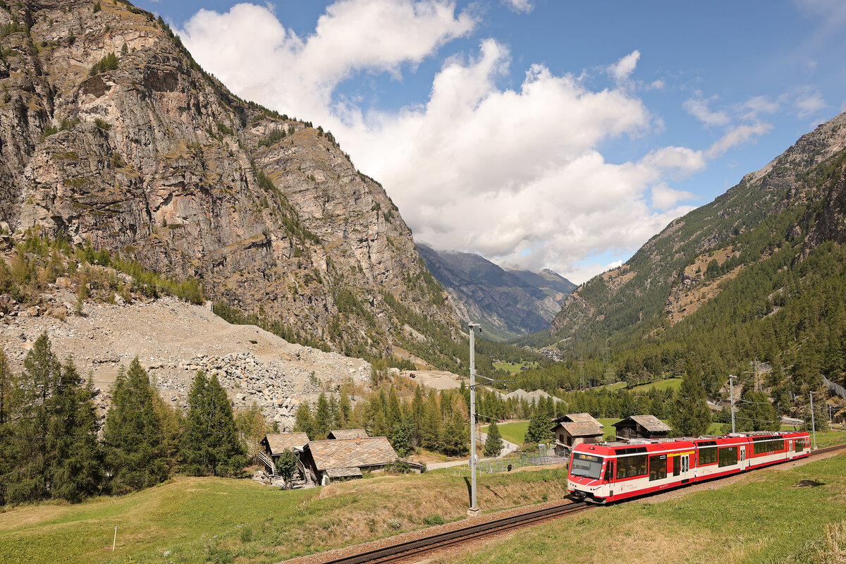 Der Bergsturz von Randa: Statt sich in Richtung Randa - Zermatt talaufwärts zu schlängeln muss die Bahn jetzt die steile Umfahrung des Bergsturzes in Angriff nehmen, um dann danach wieder steil abwärts zum Bahnhof Randa zu gelangen. Hier kommt Triebwagen ABDeh4/10 2013 talaufwärts den Hang der Umfahrungsstrecke herauf. 30.August 2025 