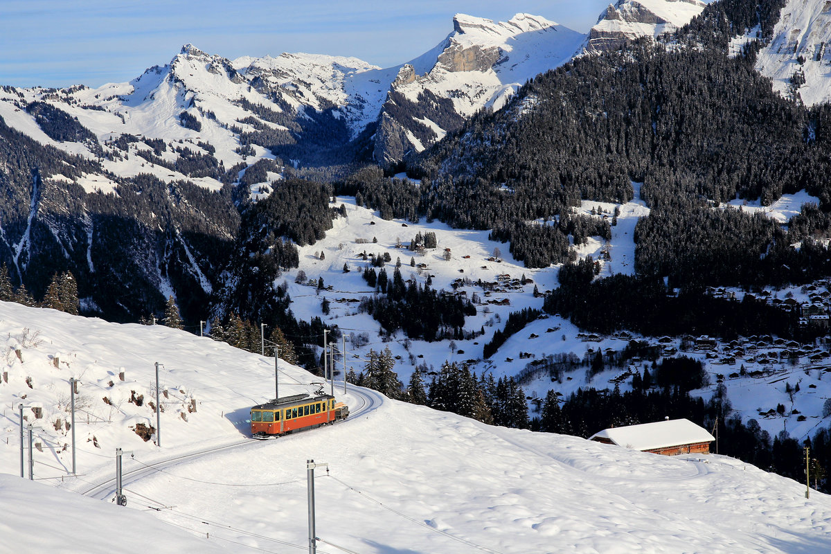Der BLM-Triebwagen 23 fährt von Winteregg nach Grütschalp davon. Da der Güterwagen immer Richtung Grütschalp steht, weiss man beim blossen Betrachten des Bildes nicht, ob der Zug kommt oder geht. Im Hintergrund Wengen, wohin die aufgehende Sonne noch nicht gelangt ist. 14.Dezember 2020 