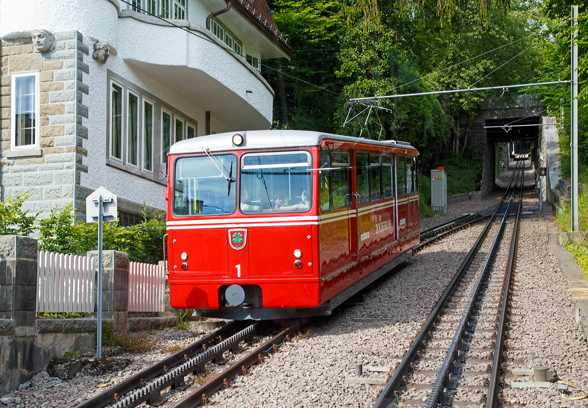 Der elektrischer Zahnradtriebwagen Bhe  1/2 Nr. 1 der Dolderbahn muss am 06.06.2015 in der Ausweichstelle auf den Gegentriebwagen Nr. 2 warten.

Die beiden Elektrischer Zahnradtriebwagen Bhe  1/2 der Dolderbahn
Im Jahr 1972 stellte die Dolderbahn- Betriebs AG den Seilbahnbetrieb ein, verlängerte die Strecke um rund 500 m auf 1,3 km und verlegte eine Lamellenzahnstange (System von Roll) in das erneuerte Gleis. Für den Zahnradbetrieb lieferte die SLM 1973 zwei zweiachsige Zahnradtriebwagen. Jeder dieser Zahnradtriebwagen hat talseitig eine Triebachse und bergseitig eine Bremsachse. Ein im Untergestell in Längsrichtung angeordneter Fahrmotor treibt über eine Kardanwelle und ein zweistufiges Getriebe das Triebzahnrad an. Die Verbundbauweise des Wagenkastens mit dem Untergestell ergibt eine selbsttragende, leichte und solide Konstruktion.  Volle Betriebssicherheit wird durch eine elektrische Widerstandsbremse, eine Zahnradbremse sowie eine Klinkenbremse gewährleistet.

TECHNISCHE DATEN:
Hersteller: SLM (Schweizerische Lokomotiv- und Maschinenfabrik), Winterthur
Elektrischen Ausrüstung: BBC (Brown, Boveri & Cie. AG), Baden
Spurweite: 1.000 mm (Meterspur)
Zahnstangensystem: von Roll
Achsformel: 2z
Max. Steigung: 196 ‰
Länge über Puffer: 11.520 mm
Achsabstand: 5.400 mm
Laufraddurchmesser: 690 mm
Teilkreisdurchmesser Treib- und Bremszahnrad: 573 mm
Eigengewicht: 14,4 t
Max. Zuladung: 7,8 t
Leistung: 131,5 kW (dauernd) / 149,5 kW (einstündig)
Zugkraft: 22,9 kN (dauernd) / 27,2 kN (einstündig)
Höchstgeschwindigkeit: 25 km/h (Bergfahrt) / 16 km/h (Talfahrt)
Getriebeübersetzung: 1 : 10,45
Sitzplätze: 26
Stehplätze: 74
Fahrdrahtspannung: 600 V = (DC)

Die Dolderbahn ist eine Privatbahn in der Stadt Zürich. Die Zahnradbahn erschließt das Dolder-Gebiet im Quartier Hottingen ab der Haltestelle Römerhof am Römerhofplatz auf 444 Metern über Meer und endet in der Station Dolder auf dem Adlisberg auf 606 Metern über Meer. Die Bahn dient nebst der Verbindung mit dem Wohnquartier auch als Zubringer für zwei Hotels, dem Wellenbad Dolder, der offenen Eisbahn Dolder und dem als Naherholungsgebiet dienenden Adlisberg.

Die Betreibergesellschaft wurde 1893 gegründet. 1895 wurde der Betrieb als Standseilbahn aufgenommen. Sie führte auf einer Strecke von rund 800 Metern vom Römerhofplatz zum Hotel Waldhaus Dolder auf 548 Metern über Meer.

Zur Verbindung mit dem Grand Hotel Dolder wurde am 5. Juli 1899 ein meterspuriges Tram in Betrieb genommen. Es wurde mit einem einzigen Wagen gleicher Bauart wie die StStZ-Wagen 57–84 betrieben. Die Strecke hatte keine direkte Verbindung zum Zürcher Tramnetz, jedoch sorgte die StStZ für den Unterhalt des Motorwagens und stellte während einer längeren Revision einen Ersatzwagen. Am 31. Dezember 1930 wurde das Dolder-Tram eingestellt und ein Bus übernahm die Verbindung zwischen Waldhaus und Grand Hotel.

Zwischen 1972 und 1973 wurde die Standseilbahn durch eine Zahnradbahn ersetzt und die Strecke bis zum Grand-Hotel Dolder verlängert. Weil dazu eine Kurve nötig war, wurde aus der Seil- eine Zahnradbahn. Seither misst sie 1.328 Meter und überwindet dabei eine Höhendifferenz von 162 Metern mit einer Neigung von maximal 19,6 Prozent. Weitere Vorteile gegenüber einer Standseilbahn sind, die Bahntrasse kann besser dem Gelände angepasst werden, die Ausweichstelle muß nicht genau in der Mitte der Bahnstrecke liegen. Zudem ist ein Einwagenbetrieb oder ein späterer Ausbau für automatischen Betrieb möglich.
