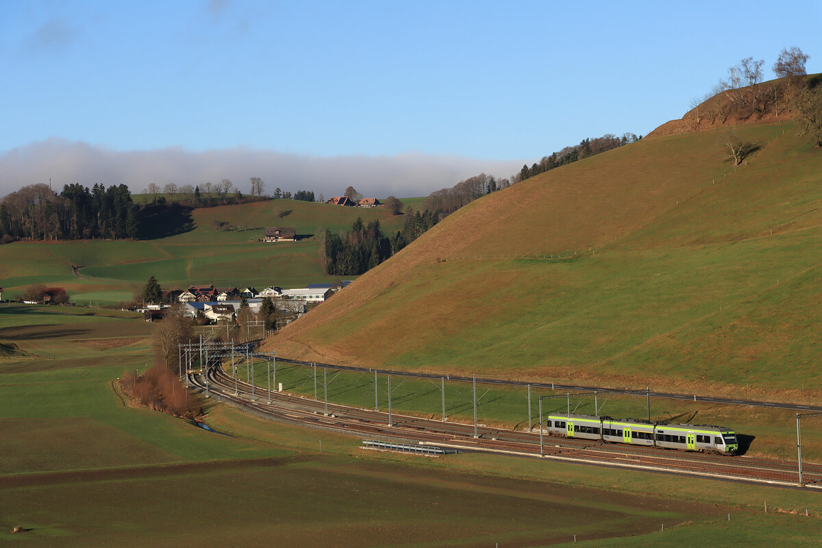 Die ehemalige VHB (Vereinigte Huttwil-Bahnen) / Strecke der ursprünglichen Huttwil-Wolhusen Bahn (HWB): Gerade hat BLS NINA 525 030 das luzernische Hüswil Richtung Huttwil im Norden verlassen und überquert die Kantonsgrenze und damit die kulturelle, dialektsprachliche, konfessionelle und architektonische Grenze zum Kanton Bern. Das bernische Gondiswil ist im Hintergrund sichtbar. 31.Dezember 2021  