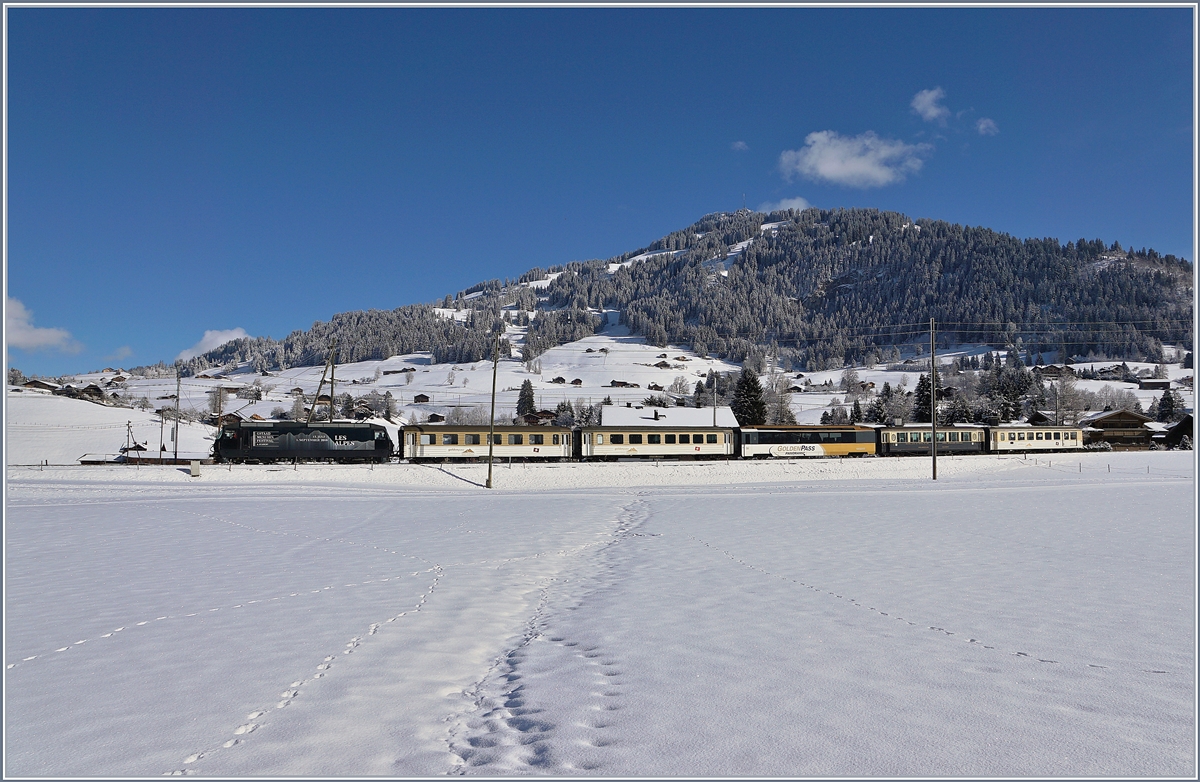 Die MOB Ge 4/4 8003 fährt mit ihrem  MOB-Belle  Epoque Zug bei Gstaad Richtung Montreux. Da die  Belle-Epoque Wagen zur Zeit in Chernex auf automatische Kupplung umgebaut werden, verkehr der Zug (wie im Fahrplan vorgesehen) mit  klassischem  Rollmaterial, wobei überraschenderweise doch noch ein  Belle-Epoque Wagen mitgeführt wird.
2. Feb. 2018