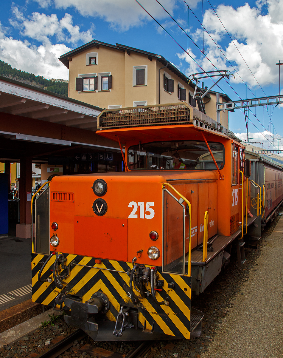 Die RhB Ge 3/3 - 215 steht am 06.09.2021 mit einem Güterzug im Bahnhof Samedan (1.705 m.ü.M.), aufgenommen aus einem Zug heraus.

Die Ge 3/3 ist eine dreiachsige elektrische Rangierlokomotive der Rhätischen Bahn (RhB). Bei der RhB zeigte sich Anfang der 1980er Jahre ein Engpass an Rangierlokomotiven, da die umgebauten und knapp 70-jährigen Ge 2/4 bedingt durch ihr Alter immer störanfälliger wurden. Ebenfalls reichte ihre Leistung nicht mehr aus, um wirtschaftlich arbeiten zu können. Die RhB entschied sich daher, gleichzeitig mit der Bestellung der zweiten Serie der Ge 4/4 II zwei moderne und leistungsfähige Rangierlokomotiven anzuschaffen.

Da man bei der ersten Serie der Ge 4/4 II gute Erfahrungen gemacht hatte, entschied man sich, die beiden Rangierlokomotiven ebenfalls in Thyristortechnik zu bauen. Die Thyristoren bilden zusammen mit Dioden einen stufenlos steuerbaren Gleichrichter, welcher den Gleichstrom-Reihenschlussmotor mit welligem Gleichstrom versorgt.

Der mechanische Teil wurde von Robert Aebi (RACO) gebaut. Der elektrische Teil stammt gleich wie bei der Ge 4/4 II von BBC. Einige Komponenten der Fahrzeuge – beispielsweise Fahrmotor, Kompressor und Vakuumpumpe – stimmen mit den entsprechenden Bauteilen der zweiten Serie Ge 4/4 II überein. Die beiden Maschinen mit den Betriebsnummern 214 (RACO Fabriknummer 1889) und 215 (RACO Fabriknummer 1899) wurden 1984 in Betrieb genommen.

TECHNISCHE DATEN:
Hersteller: RACO/ BBC
Spurweite: 1.000 mm
Achsformel: C
Länge über Puffer: 8.640 mm
Breite: 2.700 mm
Dienstgewicht: 33 t
Höchstgeschwindigkeit: 40 km/h (65 km/h Schleppfahrt)
Stundenleistung: 425 kW
Anfahrzugkraft: 102 kN
Stundenzugkraft: 60 kN bei 27 km/h
Treibraddurchmesser: 920 mm
Motorbauart: Reihenschlussmaschine
Stromsystem: 11 kV 16,7 Hz