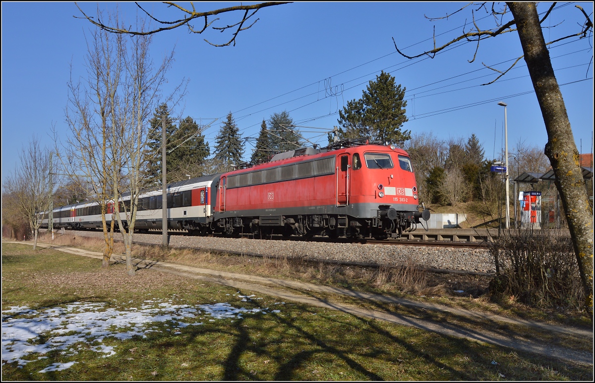Diesmal für Stefan: Der deutsche Fotograf kann auch deutsche Loks vor Schweizer Zügen... 

115 383-2 durchfährt mit IC 185 den Haltepunkt Singen Landesgartenschau. Schön sieht man die zumindest von der Form her noch originale Lüfterreihe der Bügelfalte. Vielleicht wird sich in absehbarer Zeit ein Museumsfahrzeug wieder im Originalzustand zeigen. Februar 2015.