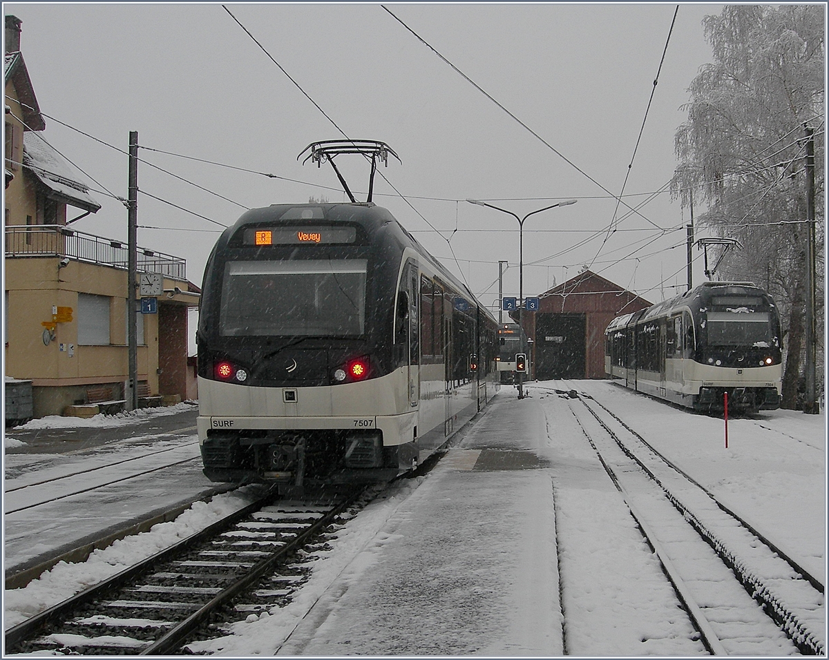 Ein Bild ohne Motiv, freilich sind zwei  MVR ABeh 2/6 in Blonay zu sehenen und ein dritter erreicht gerade den Bahnhof, doch das eigentliche Motiv ist der Schneeräumzug, bzw. das offene Schuppentor im Hintergrund, welches besagt, dass der Schneeräumzug unterwegs ist.

3. Feb. 2019