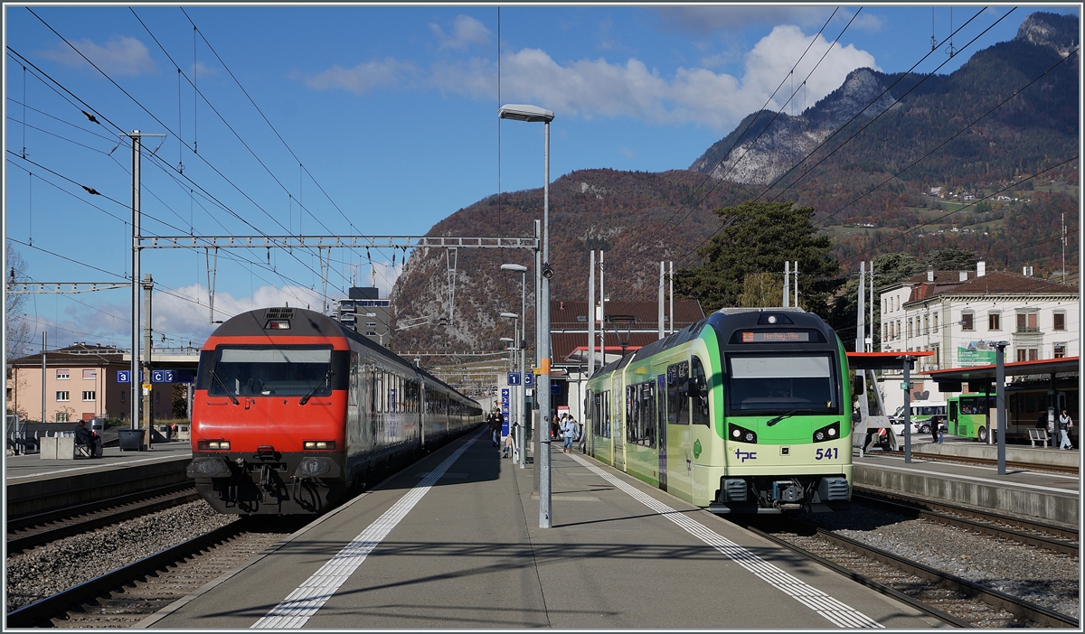 Ein IR90 von Genève nach Brig vermittelt in Aigle auf dem selben Bahnsteig Anschluss an die TPC und insbesondere in Richtung Monthey, bzw. Champéry. Dazu wartet der TPC AOMC/ASD Beh 2/6 541  Cime de l'Est  auf die Anschlussreisenden. Die sieben Triebwagen Beh 2/6 sind mit den Namen der sieben Gipfel der mächtigen Dents de Midi versehen und eine schematische Zeichnung beim Namen zeigt, wo sich der entsprechende Gipfel befindet. 

5. Nov. 2021