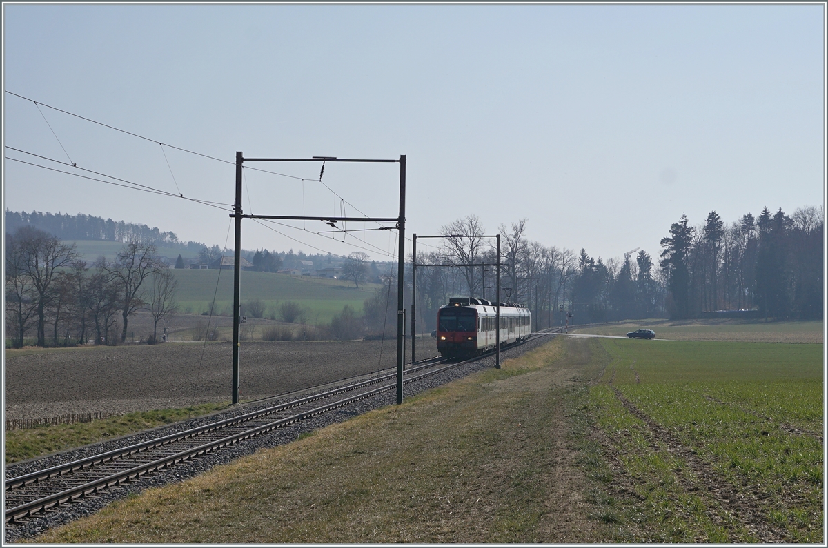 Ein SBB Domino ist zwischen Courtepin und Cressier FR auf dem Weg in Richtung Murten und passiert hier die typischen GMF Fahrleitungsmaste.