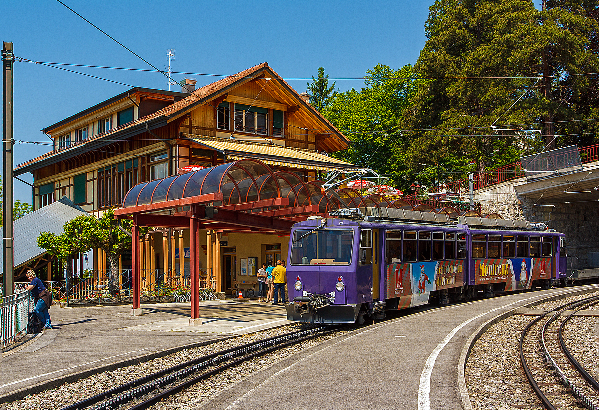 Ein Weihnachtsbild aus dem Mai.... 
Der Triebwagen Bhe 4/8 303 „Villeneuve“  der Transports Montreux-Vevey-Riviera (MVR), ex Chemin de fer Glion–Rochers-de-Naye (GN) am 26.05.2012 beim Halt auf der Talfahrt im Bahnhof Glion.

Auch wenn hier das Bild im Mai 2012 gemacht wurde, so passt es doch sehr gut in die jetzige Vorweihnachtszeit, man schaue auf den Weihnachtsmann am Triebwagen und die Aufschift:  „Le Monde Magique du Pére Noél” , nach meiner Übersetzung in Deutsch „Die magische Welt des Weihnachtsmannes“

Der Zahnradtriebwagen Beh 4/8 303 Villeneuve wurde 1983 von SLM (Schweizerischen Lokomotiv- und Maschinenfabrik) in Winterthur gebaut, der elektrische Ausrüstung wurde von Siemens (Werk Erlangen) geliefert.

Die Bhe 4/8 sind zweiteilige kurzgekuppelte elektrische Zahnrad-Doppeltriebwagen der Transports Montreux–Vevey–Riviera (MVR), ehemalig Chemin de fer Glion–Rochers-de-Naye (GN) und der Monte Generoso-Bahn (MG). Für die damalige GN wurden insgesamt 5 Stück gebaut (3 Stück 1983, und jeweils einer 1992 und 2011). Der 2011 gebaute wurde von der MOB Werkstätte Chernex gebaut. Bei den MVR Triebwagen wurden nachträglich Mehrfachsteuerung eingebaut, so können bis zu drei Triebwagen gekuppelt und gesteuert werden.

Bereits 1982 wurden anlässlich der Elektrifizierung der Monte Generoso-Bahn vier Triebwagen von der Schweizerischen Lokomotiv- und Maschinenfabrik (SLM) in Winterthur, für die MG, gebaut. Die elektrische Ausrüstung wurde von Siemens (Werk Erlangen) geliefert. Bei der Monte Generoso-Bahn sind die Triebwagen die einzigen elektrischen Fahrzeuge, zudem weichen die Technischen Daten der MG Fahrzeuge gegenüber der MVR Fahrzeuge leicht ab.


TECHNISCHE DATEN der MVR Bhe 4/8, in Klammern der MG Bhe 4/8:
Achsformel:  2'Z 2'Z + 2'Z 2'Z
Spurweite: 	800 mm
Länge über Puffer:  23.890 mm
Achsabstand im Drhgestell:2 .200 mm
Teilkreis-Ø vom Antriebszahnrad: 611 mm
Dienstgewicht:  34 t (34,1 t)
Höchstgeschwindigkeit:  22 km/h (bergauf) / 14 km/h (talfahrt)
Stundenleistung:  800 kW (1.088 PS) bei 15 km/h
Zahnradsystem: 	Abt
Stromsystem:  850 V DC 
Anzahl der Fahrmotoren: 4
Übersetzungsverhältnis: 1:12
Gefälle:  220 ‰
Sitzplätze: 	96
Klassen: 2. Klasse
