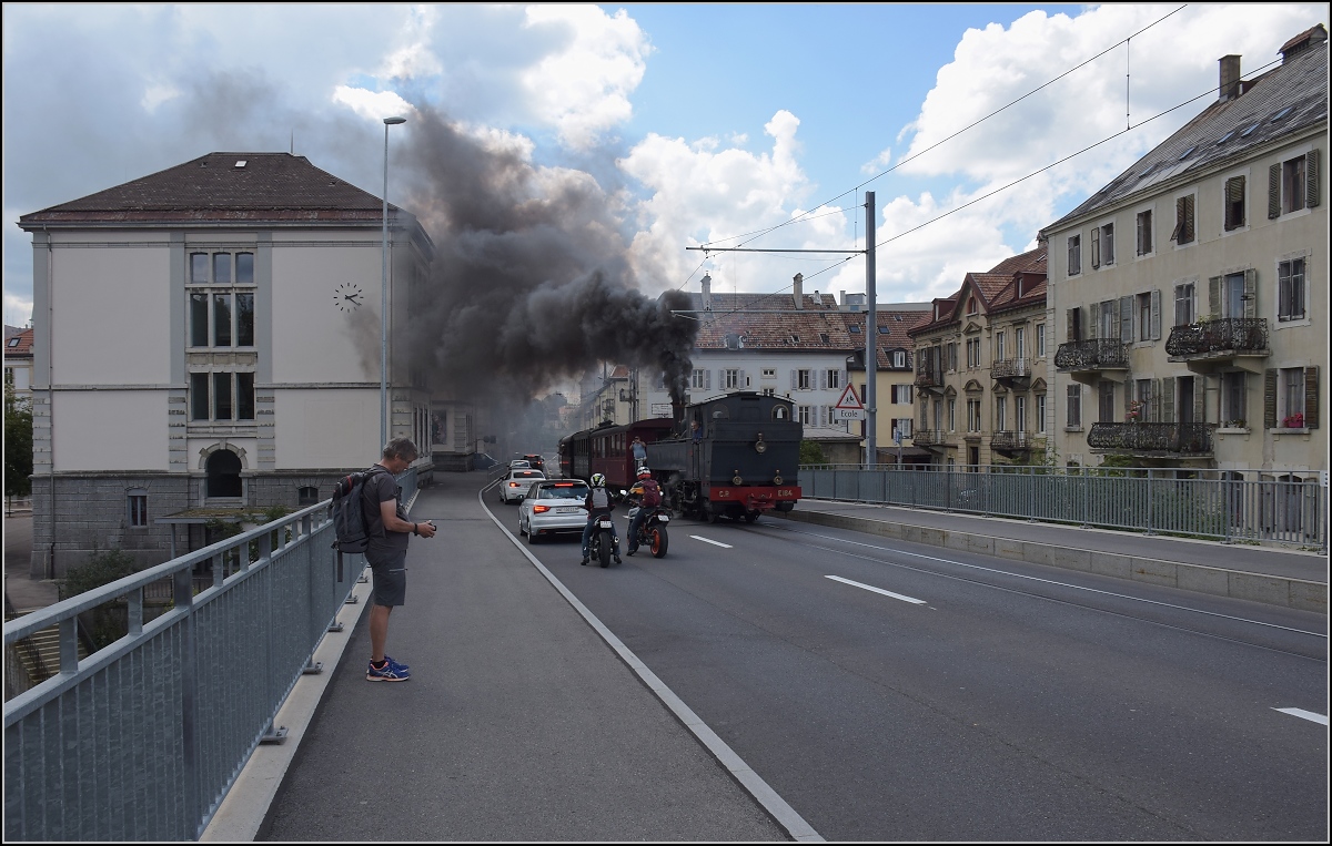 Eine etwas ungewöhnliche Verkehrsteilnehmerin in La Chaux-de-Fonds. 

Rette sich, wer kann. Denn CP E 164, heute bei La Traction, schnaubt mit viel Rauch als Geisterfahrerin die Rue du Manège hinauf. So sammeln sich respektvoll immer mehr Autofahrer und Motorradfahrer auf der falschen Strassenseite. September 2021.