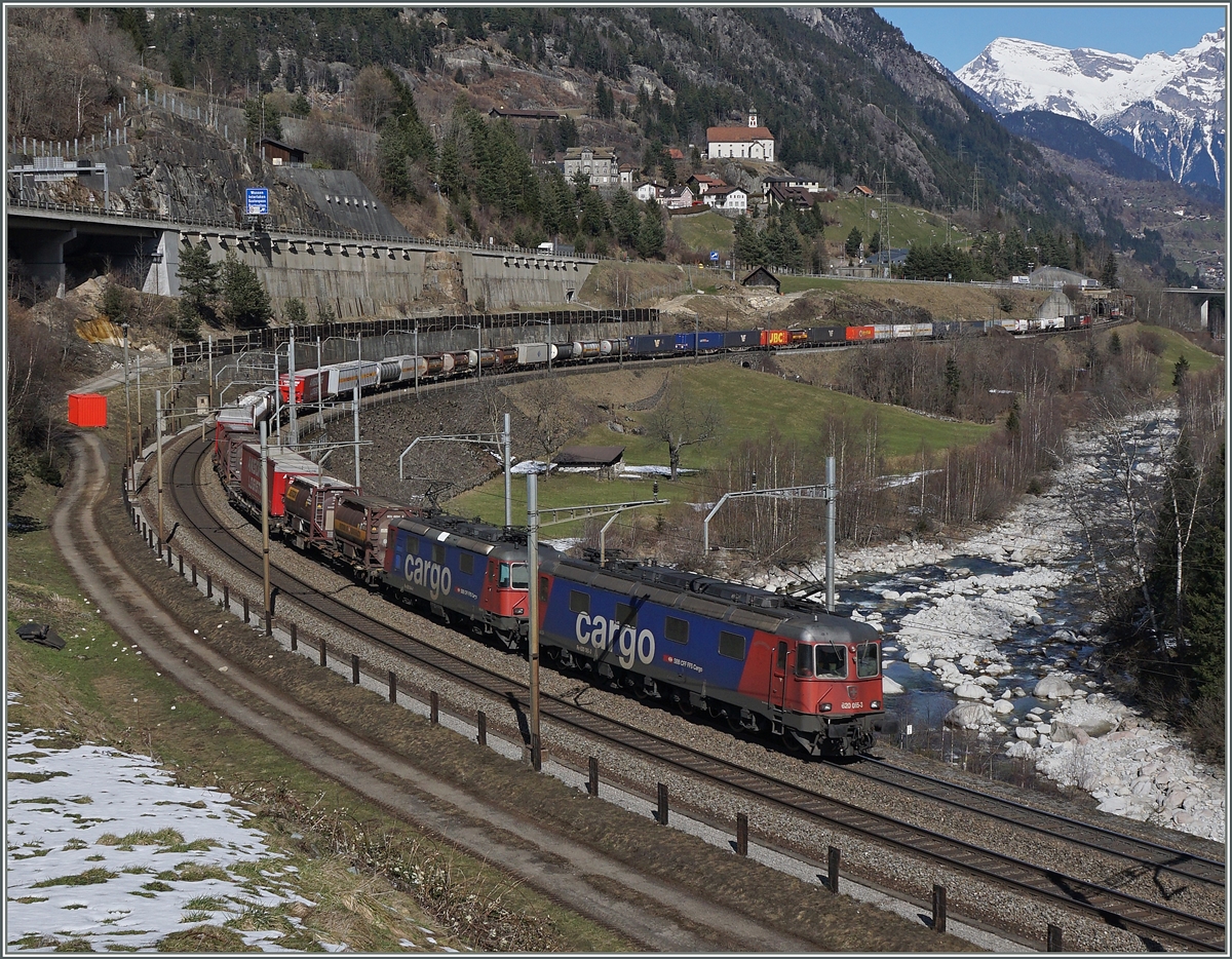 Eine Re 10/10 mit der Spitzenlok Re 620 065-3 ziehen einen langen Güterzug bei Wassen bergärts.
17. März 2016
