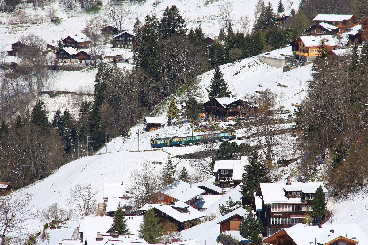 Es gibt nur noch drei klassische Triebwagenzüge der WAB auf der Strecke von Lauterbrunnen zur Kleinen Scheidegg. Hier fährt einer davon (Triebwagen 116 mit den beiden Steuerwagen 278 und 267) durch die unteren Häuser von Wengen ins Tal. Die Komposition mit Triebwagen und zwei Steuerwagen ohne Skiwagen ist bereits die Sommerformation. 