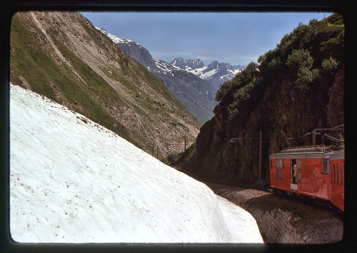 Furka Bergstrecke zur Zeit des elektrischen Betriebs: FO-Triebwagen 53 im Abstieg von Tiefenbach nach Realp. Ende Juli liegt da doch noch so viel Schnee. 28.Juli 1975  