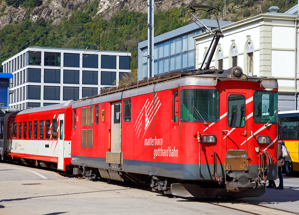 Geschoben von dem elektrischen Zahnradtriebwagen Deh 4 /4 – 55 „Brig“ erreicht der MGB Regionalzug von Andermatt am 16.09.2017 den Bahnhof Brig.

Der Gepäcktriebwagen wurde 1972 gebaut, der Lokomotivkasten ist von SIG, die Triebdrehgestelle von SLM und die elektrische Ausrüstung von BBC.

Da das Rollmaterial in den 60er Jahren großenteils veraltet und der Verkehr in der Wintersaison stark angestiegen war, benötigte die FO dringend leistungsfähigere Triebfahrzeuge. Man entschied sich für leistungsfähige Gepäcktriebwagen, die freizügig auf dem gesamten Netz eingesetzt werden konnten. Die fünf Fahrzeuge des Typs Deh 4/4 wurden 1972 bestellt und lösten die HGe 2/2 und die ABDeh 2/4 ab, die den Wintersportverkehr auf der Schöllenenbahn nicht mehr bewältigen konnten. 

Ein Nachbau der FO-Deh 4/4 erhielt einen völlig andersartigen Kasten, weshalb diese Fahrzeuge bei der FO als Deh 4/4 I und II unterschieden wurden. Seit der Fusion zur MGB ist diese Bezeichnung nicht mehr gebräuchlich, die MGB unterscheidet die Serien nach den Nummernbereichen 21, 51 und 91. Wobei sie sich schon optisch und auch technisch etwas unterscheiden.

Technische Daten Deh4/4 I (51-55):
Spurweite: 1.000 mm
Achsformel: Bo'zz Bo'zz
Länge über Puffer: 16.900 mm
Größte Breite: 2.650 mm
Größte Höhe (bei abgesenkten Stromabnehmer): 3.880 mm
Leergewicht: 48,3  t 
Dienstgewicht: 50,3 t
Maximale Zuladung: 2,0 t
Höchstgeschwindigkeit: Adhäsion 60 km/h / Zahnstange 30 km/h
Stundenleistung: 1.032 kW
Dauerleistung: 936 kW
Treibraddurchmesser: 	790 mm (Adhäsion) / 688 mm (Zahnrad)
Stromsystem: 11 kV 16,7 Hz AC
Anzahl der Fahrmotoren: 4
Größe der Ladefläche: 11,5 m2
