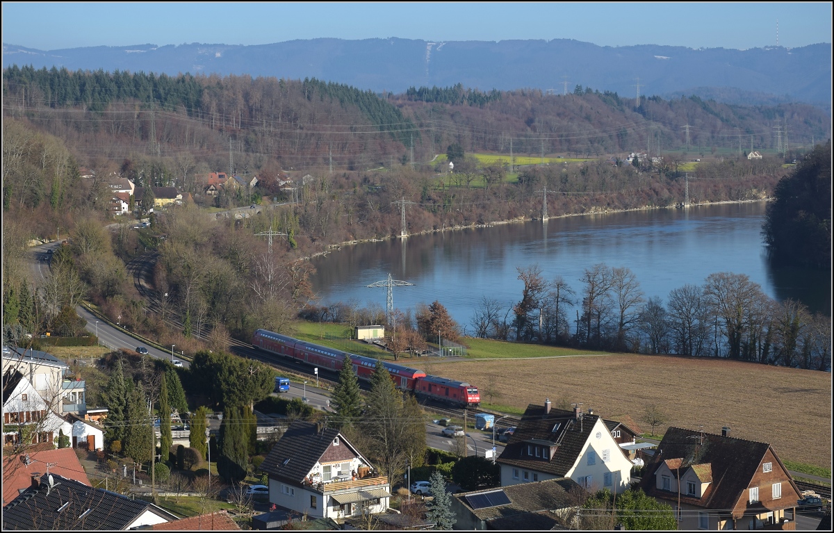 Godot-Express rechts des Hochrheins.

Eine BR 245 mit 3 Dostos. Karsau, Dezember 2021.

An jeder Station wird neuerdings erneut auf Godot gewartet. Er könnte ja noch kommen, auch wenn ihn bis heute niemand gesehen hat. Reisen im 612 war gestern, heute heißt es durch die Landschaft bummeln. Beachtenswert noch: Entgegen der Versprechung leichter und schneller Einstieg fährt hier ein Hocheinstiegsdosto mit. Sehr geschickt bei den besseren Bordsteinen in den Bahnhöfen der Hochrheinbahn. So macht es keinen Unterschied zu den Einstiegszeiten der 612er.