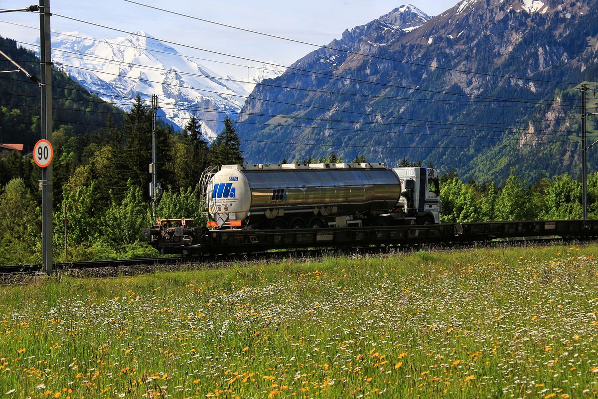 Güterverkehr auf der Lötschberg-Achse: Oft sind die hinteren Wagen der rollenden Landstrasse leer, und weil sie so niedrig sind, meint man, der Zug sei vorübergefahren. Und dann schwebt plötzlich noch ein Laster lautlos durch die Landschaft. Bei Frutigen, 23.Mai 2017.