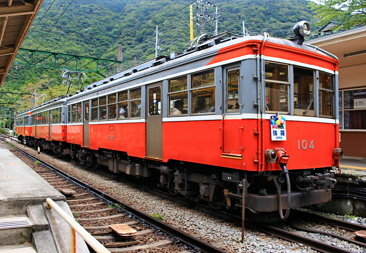 Hakone Tozan Tetsudô, Partnerbahn der RhB: Von der Station Kowakidani aus geht es mit 80 Promille steil in die (von unten gesehen) dritte Spitzkehre hinunter. Der Kurvenradius von 30 m ist dabei sehr eng. Im Bild (7.Oktober 2014) steht einer der alten Züge in der Station Kowakidani. Die Wagen 104 und 106 sind  Originalwagen  von 1919, die 1950 einen Stahlkasten bekamen. Ganz links hinten ist Wagen 110 von 1927 (1955 verblecht). Die Originalwagen 101-107 hatten die elektrische Ausrüstung und die Drehgestelle aus Amerika, 108-110 aus der Schweiz. 104 und 107 sind noch in Betrieb, 110 wurde 2017 abgebrochen.  