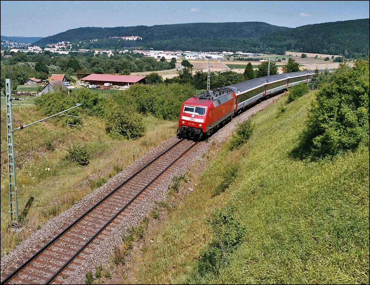IC Insubria Stuttgart-Z�rich in der Hattinger Kurve oberhalb M�hringen mit Zuglok 120, verkehrsrot und Schweizer IC-W�gen noch im grauen Farbkleid. August 2003.