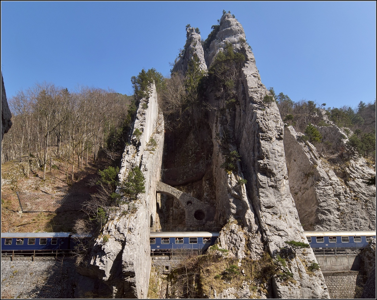 IGE-Abschiedsfahrt vom  Blauen Fernschnellzug . 

Durchfahrt der bekannten Juraklus bei Moutier/Münster. Lauter blaue DB-Schnellzugwagen eingekeilt zwischen den Felsen. März 2019.