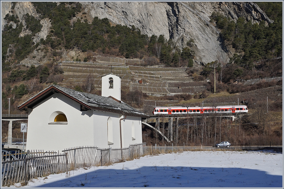 Im Vordergrund die aus dem Jahre 1445 stammende Chapelle des Sept Joies (die Sieben Freuden Marias) in Sembrancher und im Hintergrund ein RegionAlps RABe 525 als TMR Regionalzug 26118 auf dem Weg von Martigny nach Le Châble.

9. Februar 2020