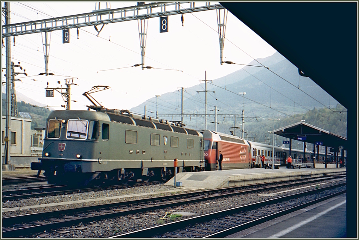 In Brig erhält eine SBB Re 460 mit einem DB EC Richtung Lötschberg Vorspann von der SBB Re 6/6 116641  Gampel Steg .

Analogbild vom Oktober 2001