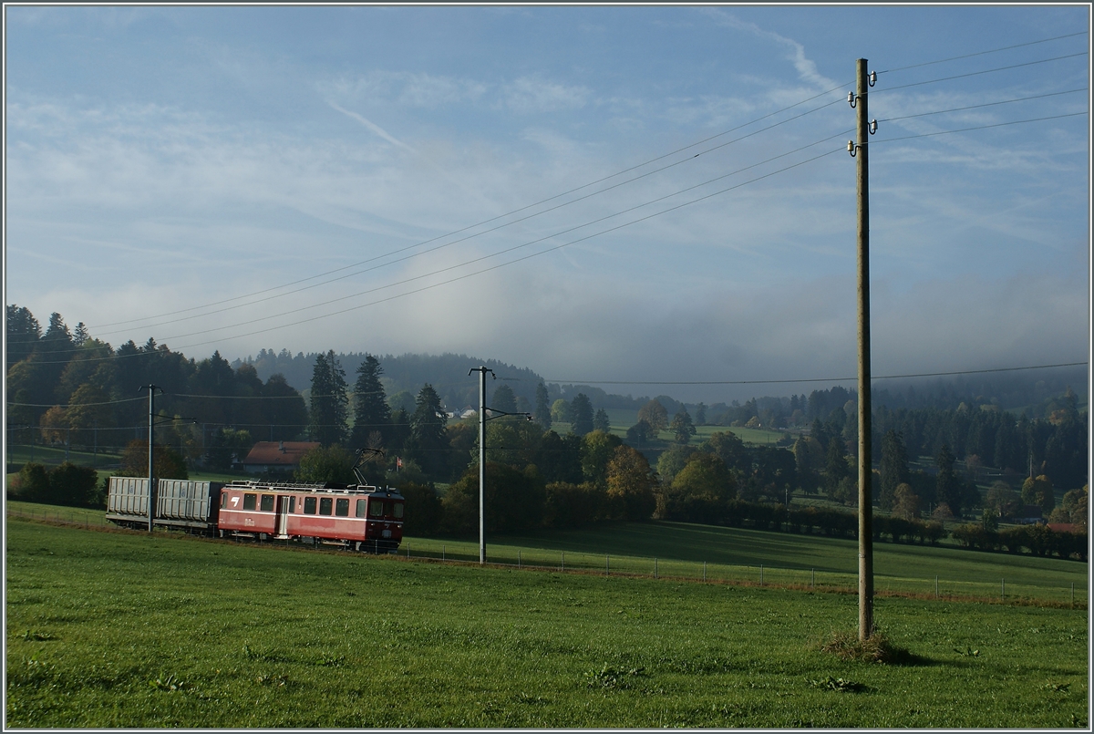 In der Weite der Juralandschaft ist bei La Cibourg ein ex RhB  Aroasbahn -Triebwagen mit einem M�ll-G�terwagen untnerwegs.
11. Okt. 2010 