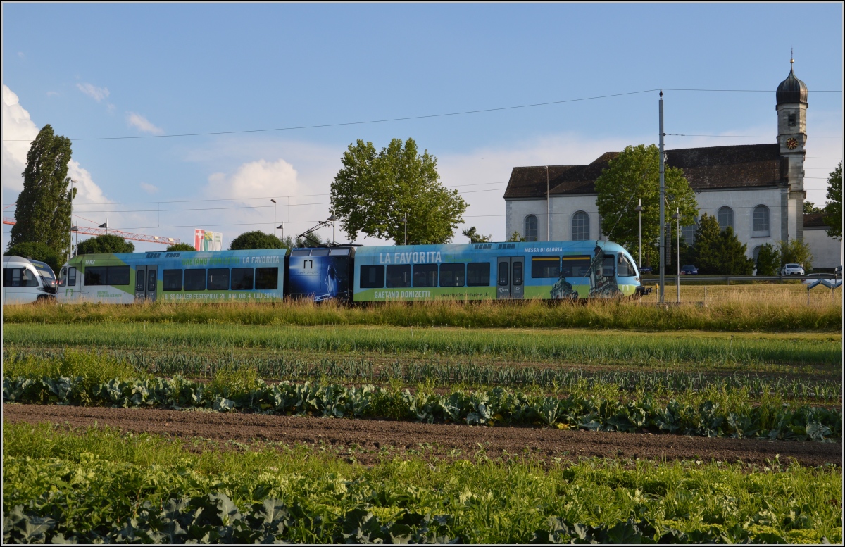 Ins rechte Licht gesetzt macht auch ein GTW was her. 

Thurbo GTW 2/8 vor der Klosterkirche des Spitals Münsterlingen. Juni 2014.