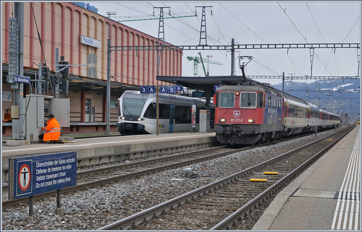 Kein Lokwechsel, aber Stromabnehmerwechsel: Nach dem Halt und Personalwechsel im Grenzbahnhof St.Margrethen hat die SBB Re 421 371-6 den vorderen Stromabnehmer mit der deutlich schmäleren, SBB konformen Wippe angehoben.
links im Bild ein Thurbo GTW als S 3 nach St.Gallen.

14. März 2019
