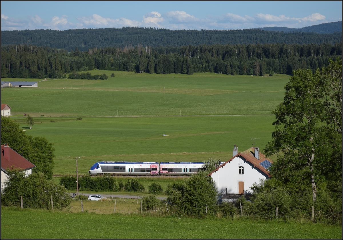 Ligne des Horlogers.

Vom Col de Tonet kommt ein unbekannt gebliebener X 76500 herunter gefahren. Die Schienenstösse kündigen den Zug lange vorher an. Das eigentlich unspektakuläre Bild zeigt einen Blick in die Jurahochebenen, die der Zug zwischen dem Doubs und Besançon durchfahren muss. Hier keine 40 m unterhalb des Tonet-Tunnels. Im Hintergrund die Wälder um Morteau. Ganz absichtlich ist das Bild jedoch nicht entstanden, der Zug kam unerwartet aus der anderen Richtung. Gilley 2022.