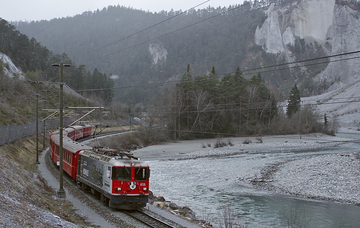 Mit einem RE von Disentis-Muster nach Scuol-Tarasp durchfährt die Ge 4/4 II 616  Filisur  die Rheinschlucht bei Versam-Safien. Mit der Werbung soll  Kohle  für die Dampflok 1 der RhB gesammelt werden.