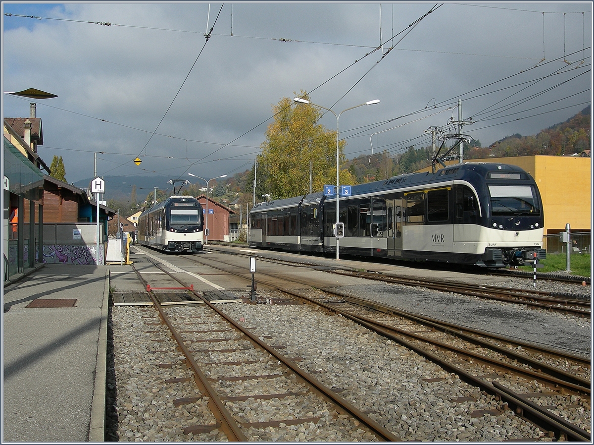  Regio Express  nach Prélaz und der Regionalzug 1428 nach Vevey warten in Blonay auf Abfahrt. 
15. Nov. 2016