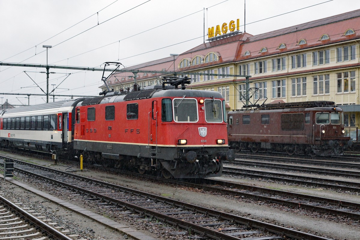 SBB/BLS/DB: Fotografieren in Singen am 20. November 2015 trotz starkem Wind und Dauerregen. An diesem Freitag konnten gleich zwei braune BLS Re 4/4 in Singen beobachtet werden. Begegnung zwischen der SBB Re 4/4 II 11300 und der BLS Re 4/4 164.
Foto: Walter Ruetsch