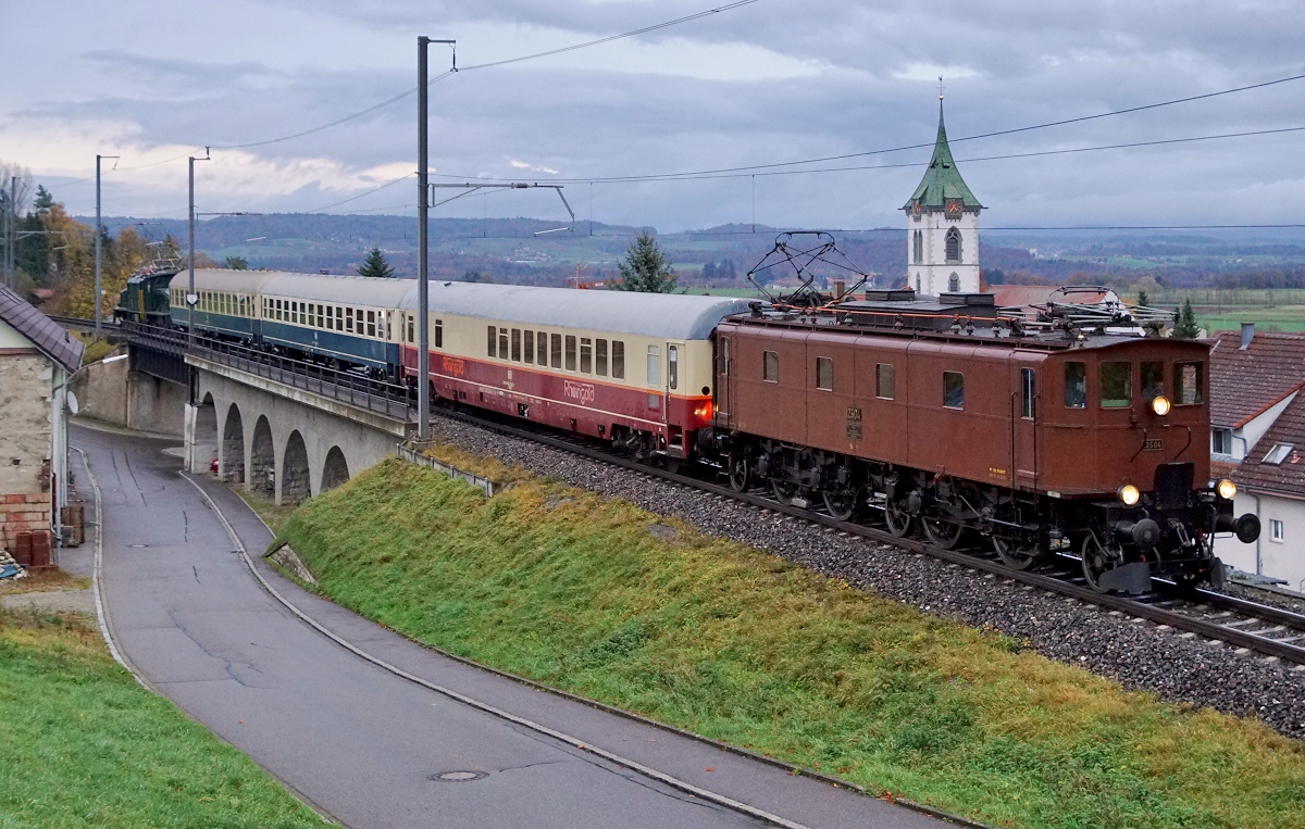 SBB/DB: DB/SBB HISTORIC: 
Rückführung der Ce 6/8 III 14305 von Meiningen bis Olten nach zwei Jahren.
Die Überfuhr  wurde vom 3. November bis 5. November 2017 durch das Team Lützel durchgeführt. Als Zugloks standen die 140 423 sowie die 218 460 vom DB Museum Koblenz im Einsatz. Als Begleitwagen für Eisenbahnfreunde wurden zwei Bm und der Clubwagen mitgeführt. Die 218 460 machte sich bereits kurz nach der Ankunft in Singen nach der Betankung als Lokzug auf die Rückfahrt. In Schaffhausen wurden die Ce 6/8 III 14305 und die Begleitwagen von der Be 4/7 12504 übernommen für die Weiterfahrt nach Olten.
Diese Aufnahme vom 5. November 2017 dokumentiert die Überfuhr bei Lottstetten am späten Nachmittag bei schlechten Lichtverhältnissen.
Foto: Walter Ruetsch  