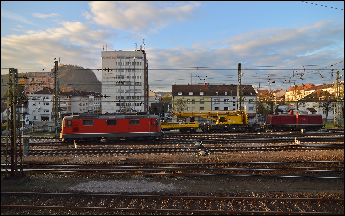 Unter dem Hohentwiel setzt sich Re 4/4 II 11114 vor IC 187 nach Z�rich. Im Hintergrund 212 133-3 mit einem Schienenkran. November 2013.