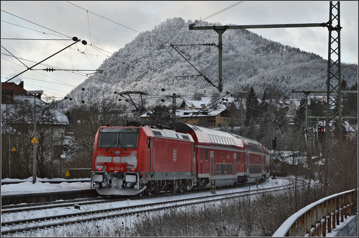Unter Vulkanen. Dieser Regionalexpress bekommt in zwei Jahren eine Aufwertung. Dann wird er bis Zürich verlängert und als IC geführt. Für den Fahrgast klasse, nur leider werden dann auch die länger lebenden totgesagten 110er auf Gäubahn endgültig verschwinden. Untem Hohenhewen, Engen, Januar 2015.  
