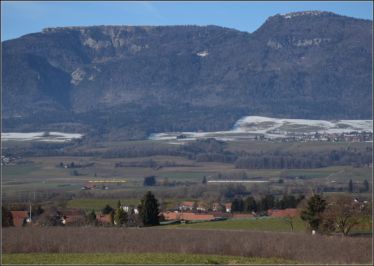 Viel Landschaft, wenig Zug am Jura. 

Zugbegegnung zwischen Bettlach und Selzach. Ein ICN Richtung Solothurn trifft auf einen Postzug mit einer Re 4/4 II. Oben sind links Stallflue und rechts der Hasenmatt zu sehen, beide überragend die Bahnlinie um 1000 Höhenmeter. Januar 2022. 