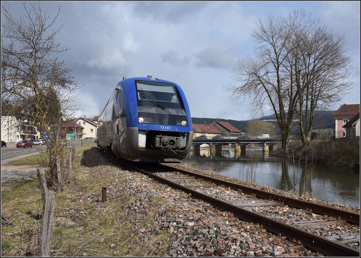 X 73755 bei der Ausfahrt aus Morteau mit dem hochwasserführenden Doubs. April 2018.