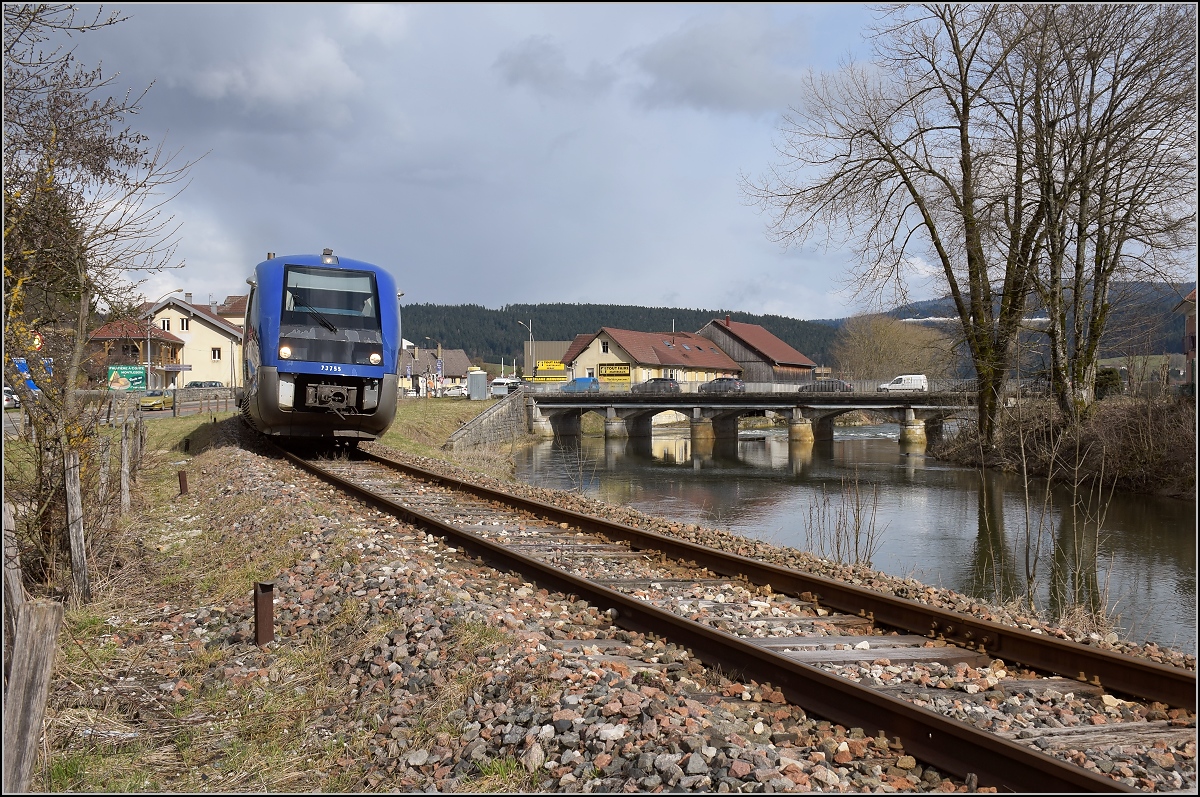X 73755 bei der Ausfahrt aus Morteau mit dem hochwasserführenden Doubs. April 2018.
