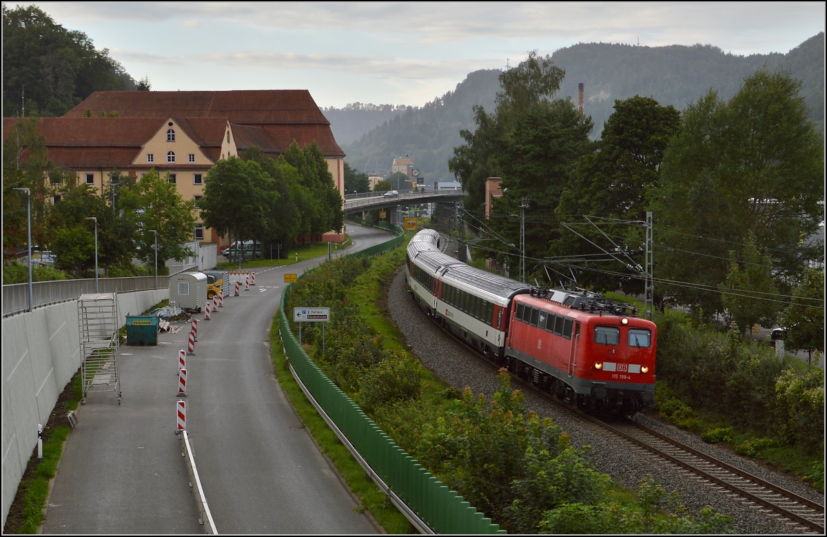 Zürichwärts auf der vielgescholtenen Gäubahn. Zwar schickte mir Petrus eine dunkle Fotowolke, die DB hingegen die 115 198-4. Das ist sicher keine schlechte Variante. Im Hintergrund der schicke  Neubau  des Augustinerklosters aus den Jahren 1772 bis 1779, heute als Rathaus genutzt. August 2014.