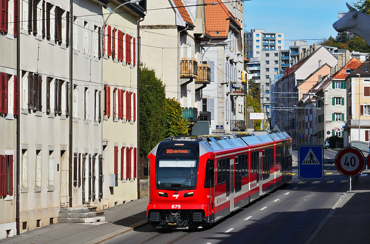 Zwar ist die Innenstadtstrecke in La-Chaux-de Fonds nur einige hundert Meter lang, doch sie bietet eine Vielzahl schöner Fotomotive, die allerdings erst am Nachmittag von der Oktobersonne beschienen werden. Nach einer Pause in einem Cafe am Marktplatz kam mir der aus Glovelier kommende ABe 4/12 675 in der Rue de Manege bei optimalem Sonnenstand entgegen (11.10.2025).