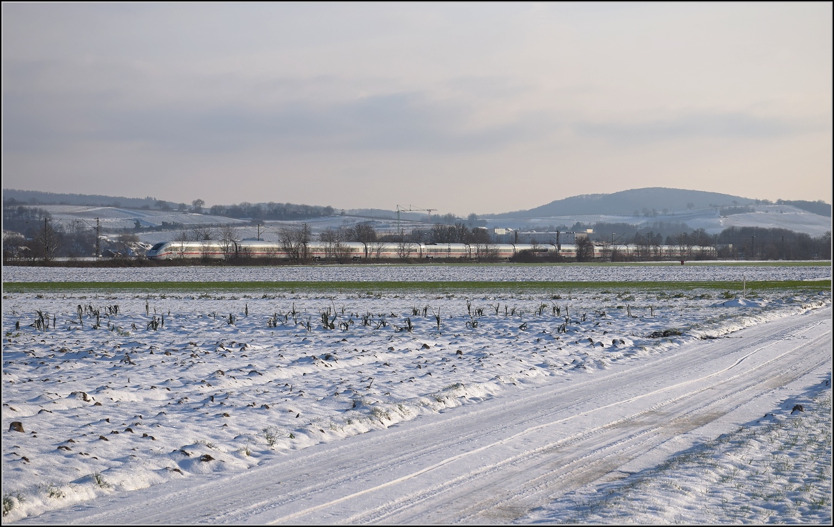Zwischen Belchensystem und Blauendreieck. 

412 038 ist bei Buggingen an der noch nicht entstandenden Fotostelle südwärts unterwegs. Februar 2021.