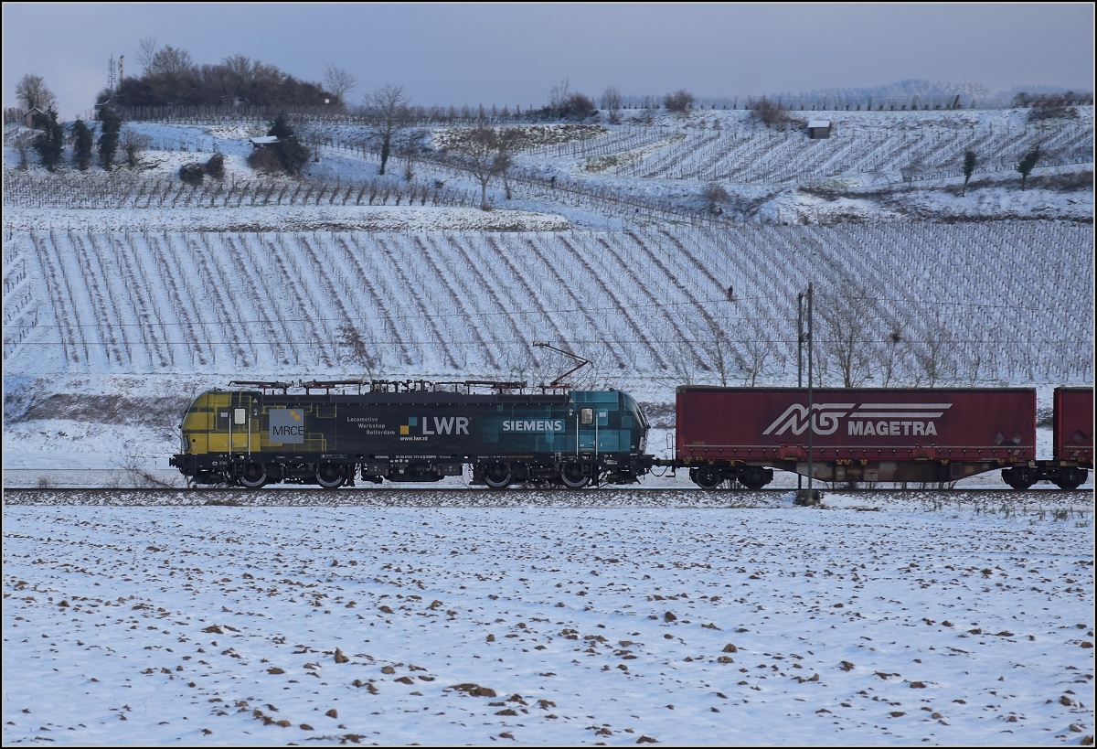 Zwischen Belchensystem und Blauendreieck.

193 717 vom Locomotive Workshop Rotterdam zieht ihren Zug von Basel gen Norden. Buggingen, Februar 2021.